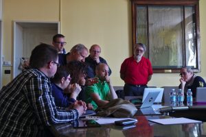 Project partners gather round to look at a notebook screen where the latest version of the visualisation platform is shown.